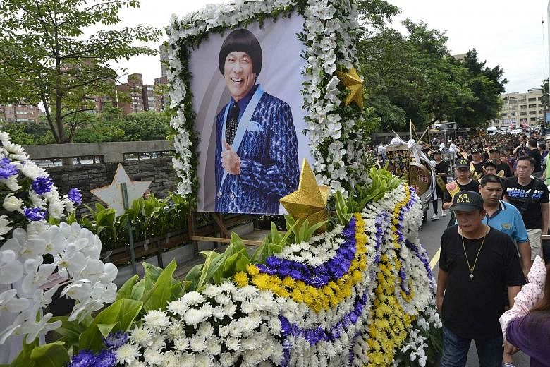A car covered with flowers and carrying Chu Ke-liang's portrait led the huge procession, followed by lion and dragon dancers, a marching band and a dozen luxury cars.