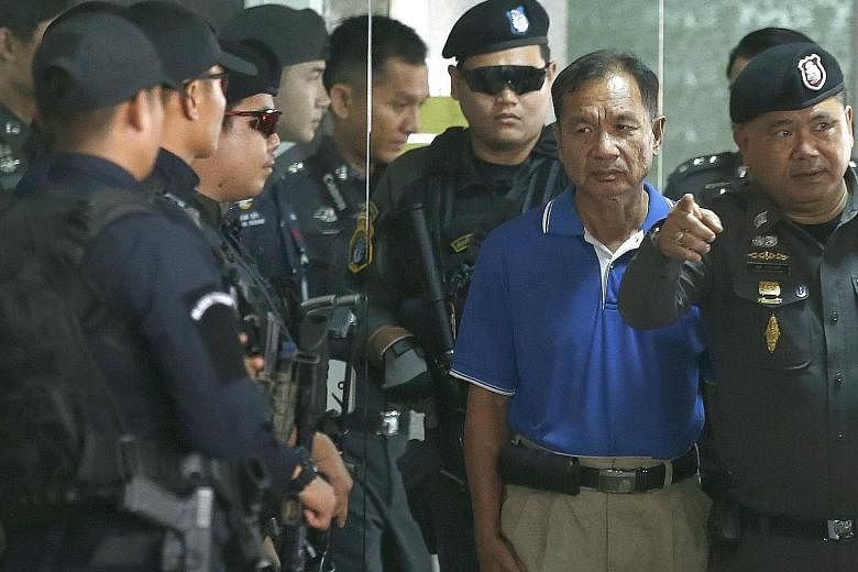 Suspect Watana Pumret being escorted by Thai police after a press conference in Bangkok yesterday. He said he acted alone in last month's attack. He also took responsibility for two smaller explosions in the Thai capital last month.