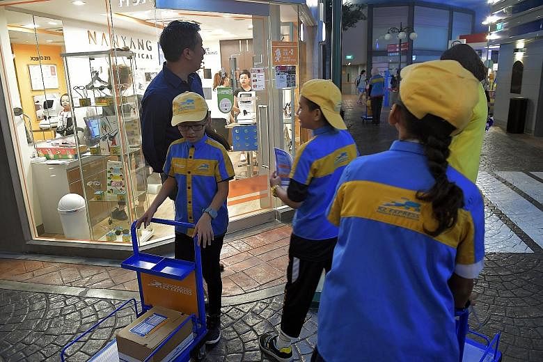 ST news editor Marc Lim with pupils who tried out being couriers at KidZania, including Beh Ke Xuan (left) and Muhammad Aliff Mattin Abdul Salim (centre). Pupil Natalie Choo posing for a shot with ST journalist Felicia Choo. It was taken on a Samsung