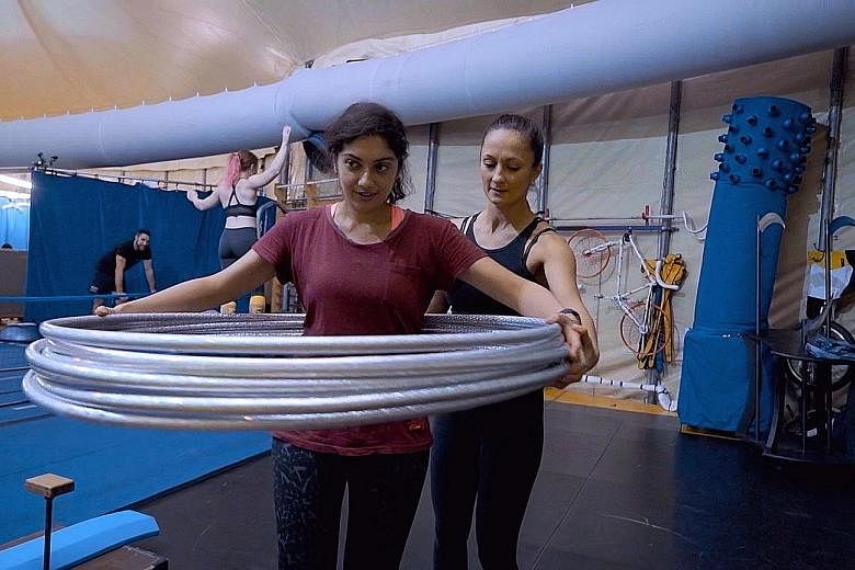 Reporter Gurveen Kaur trying hoop manipulation with Irina Akimova.