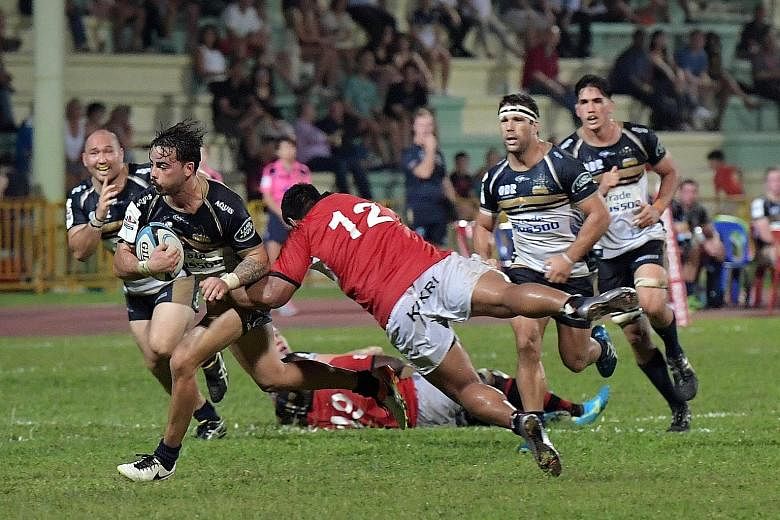 Former delivery man Andrew Muirhead of the Australian Super Rugby team Brumbies shrugs off a tackle en route to scoring a try against the Asia Pacific Dragons yesterday. The Brumbies beat the Dragons, an invitational side made up of top players from 