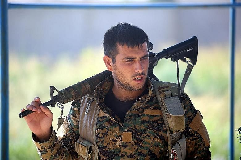 A member of the Kurdish YPG in the Syrian city of Raqqa on Wednesday, during an offensive by the US-backed fighters to capture ISIS' de facto Syrian capital. The US has told Turkey that weapons provided to the YPG in Syria would be taken back once IS