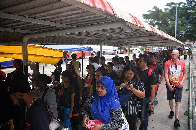 People queueing at the Queen Street bus terminal to take buses to Johor Baru at around 5.15pm yesterday. Coach operators Aeroline and KKKL, which offer services between Singapore and Malaysia, said their buses were fully booked for the day.
