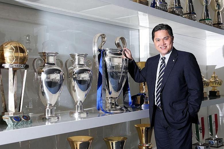 Inter Milan president Erick Thohir posing with the 2010 Champions League trophy in the club's trophy room. The Indonesian billionaire has plans for the historic Serie A club to return to their glory days, promising to invest in players and build a st