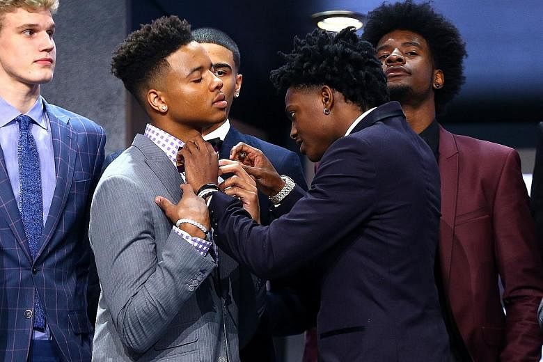 De'Aaron Fox lends a helping hand, adjusting the bow tie of his fellow rookie draftee Markelle Fultz before the first round of the NBA Draft in New York City on Thursday. Fultz, as expected, was the top draft pick and was taken by the Philadelphia 76