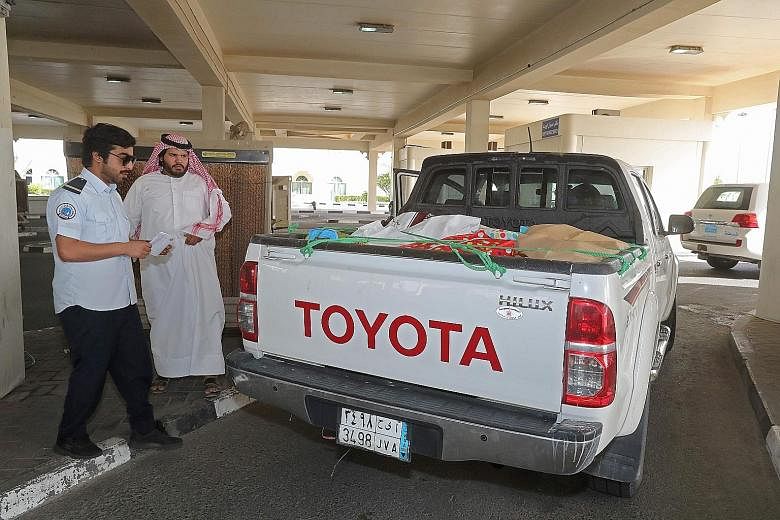 A Qatari official checking a Saudi citizen's vehicle at a border crossing with Saudi Arabia yesterday. A Saudi alliance has severed diplomatic and transport links with Qatar.