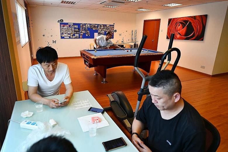 The Maritime House in Tanjong Pagar has serviced apartments for seafarers to stay in, regardless of whether they are here for work or play. Left: Electrician Zhao Yuting (far left), 52, and Captain Chen Guang Ming, 47, surfing the Internet on their c