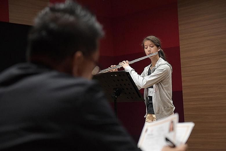 Above: Yumi Chung, 10, from Hong Kong, singing during last Friday's ChildAid audition. Left: Sharon Huang playing the flute. She hopes to make the cut so her family can watch her perform. (From left) Fevrier Eunike Wewengkang, Tesalonika Purba, Adela