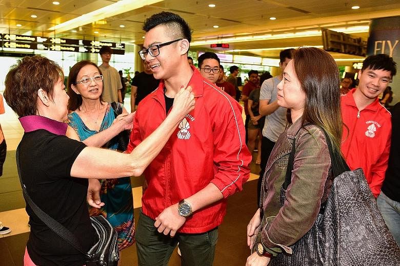 Powerlifter Matthew Yap greeting his grandaunt Mary Chua at the airport while his mother Ophelia Lim (second from right) looks on. Matthew returned with his brother Marcus (right). Singaporean Matthew Yap set a new world record with a 208kg squat in 