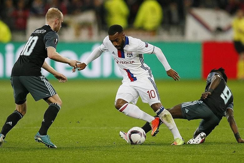 Lyon's Alexandre Lacazette (centre) takes on Ajax's Davy Klaassen after evading Bertrand Traore (right) in the Europa League semi-final last month. Arsenal are believed to be the front-runners in the race to sign the France international.