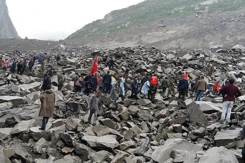 Rescuers searching the rubble for survivors yesterday after 62 homes in Xinmo village, in south-west China, were swallowed by boulders when the side of a mountain collapsed.