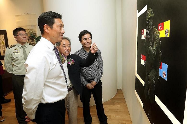Above: (From left) Chief of Army Melvyn Ong, Second Minister for Defence Ong Ye Kung, Singapore Art Society president Terence Teo and artist Tan Rui Rong at the launch of the public exhibition at Ion Art Gallery yesterday. Right: Artist Kevin Tan wit
