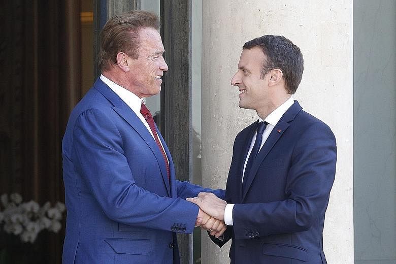 French President Emmanuel Macron with Mr Arnold Schwarzenegger in Paris last week. The US actor turned climate activist is part of a global group seeking to launch a pact to protect the environment.