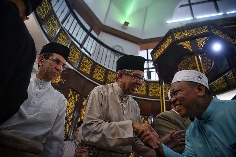 Minister-in-charge of Muslim Affairs Yaacob Ibrahim greeting a congregant after prayers at Al-Mukminin Mosque yesterday. Beside Dr Yaacob is Islamic Religious Council of Singapore president Mohammad Alami Musa.