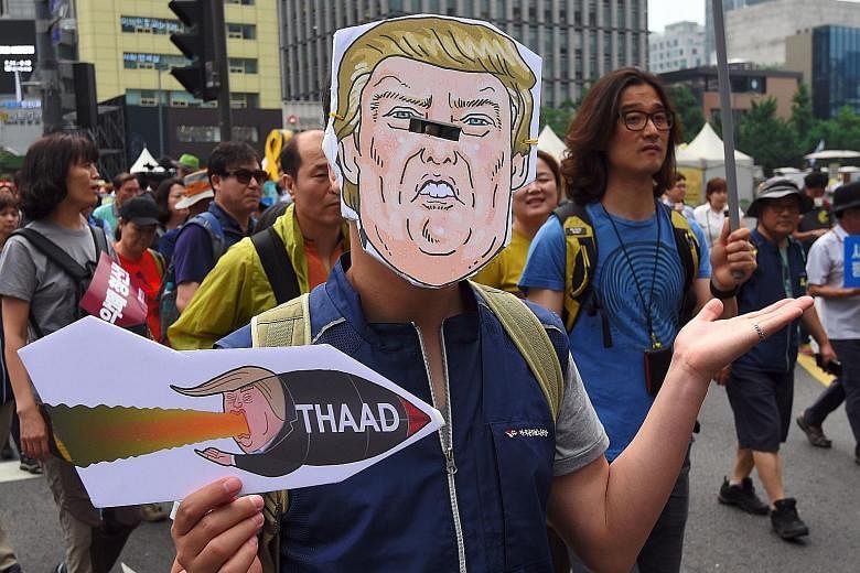A South Korean wearing a Trump mask protesting in Seoul against the deployment of the Terminal High Altitude Area Defence system.