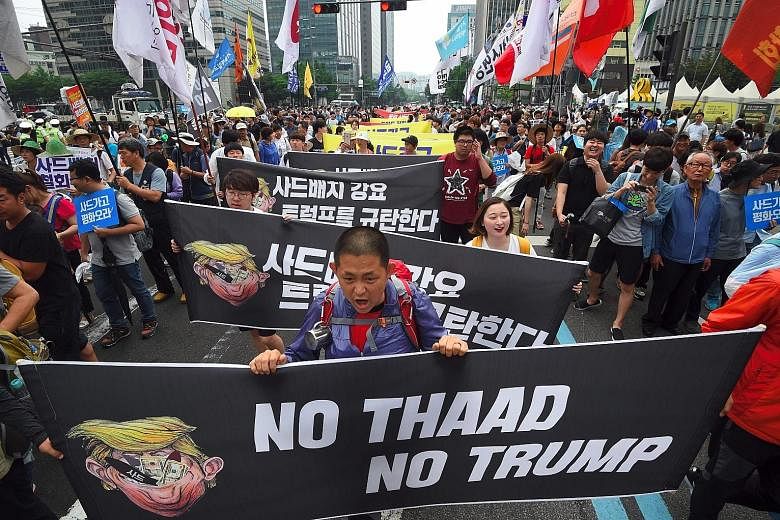 South Koreans protesting outside the US Embassy in Seoul last Saturday against the deployment of the Thaad system, and US President Donald Trump.