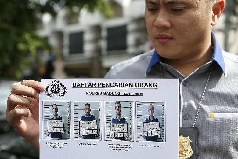 An Indonesian police officer with a release showing photos of the four inmates who escaped from Bali's Kerobokan Prison last week. The incident has highlighted the issue of overcapacity in Indonesia's prisons.