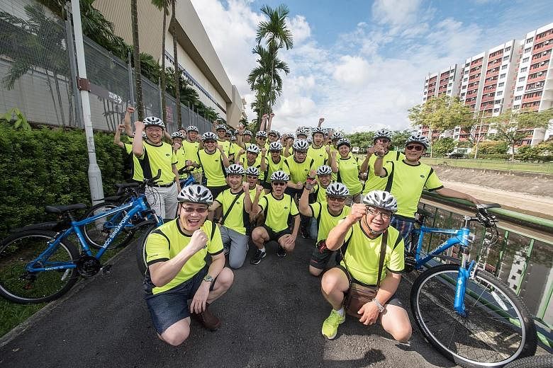 MCC Singapore managing director Tan Zhiyong (far left, standing) with other senior and management staff who took part in a 4km trial ride in Woodlands on June 3. The company will be marking its new initiative with a mass cycling activity ending at Se