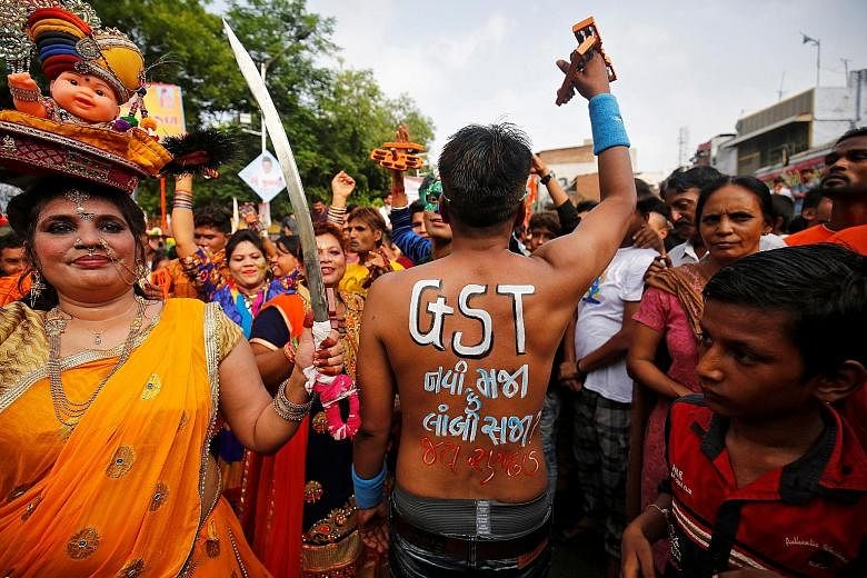 A Hindu devotee at the annual Rath Yatra, or chariot procession, in Ahmedabad, India, on Sunday, with a message on his back asking if the new tax is a boon or burden. The GST will be rolled out next month.