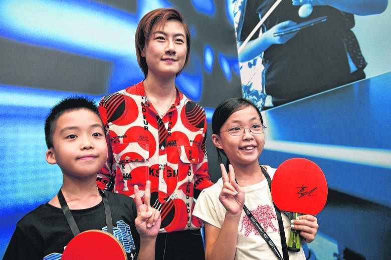 World No. 1 Ding Ning, posing with young fans Kok Cern Hann, 11 (left), and his sister, Kok Yi Mun, nine, at yesterday's curtain-raiser for the T2 Asia Pacific Table-tennis League. Ding says the 24-minute limit for matches will have a direct bearing on mo