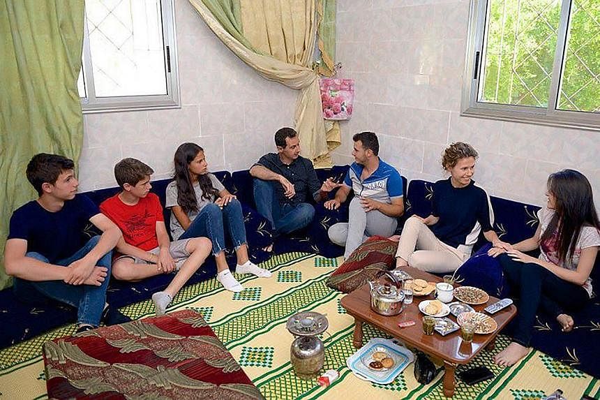 A handout photo released yesterday showing Syrian President Bashar al-Assad (centre) and (from left) his sons Hafez and Karim, daughter Zein and wife Asma visiting injured armed forces members in the central province of Hama.