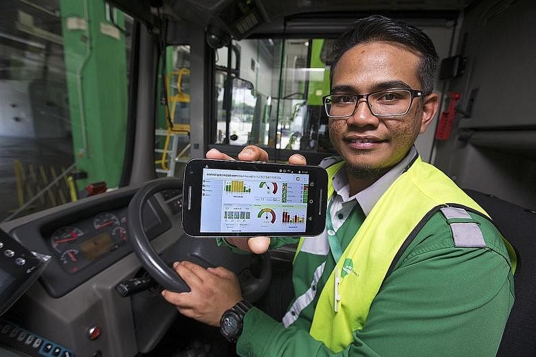 Tower Transit bus driver Amirul Hakim showing how his driving performance can be tracked and collated on a mobile phone app, which he can then review. A colour-coded panel in the bus will flash red, amber or green, according to the driver's driving p