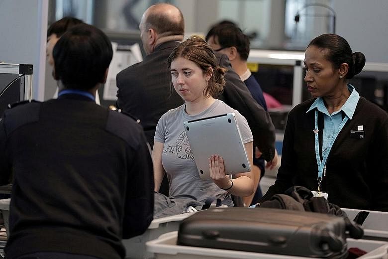 A traveller waiting for her laptop to be scanned at the John F. Kennedy airport in New York City.