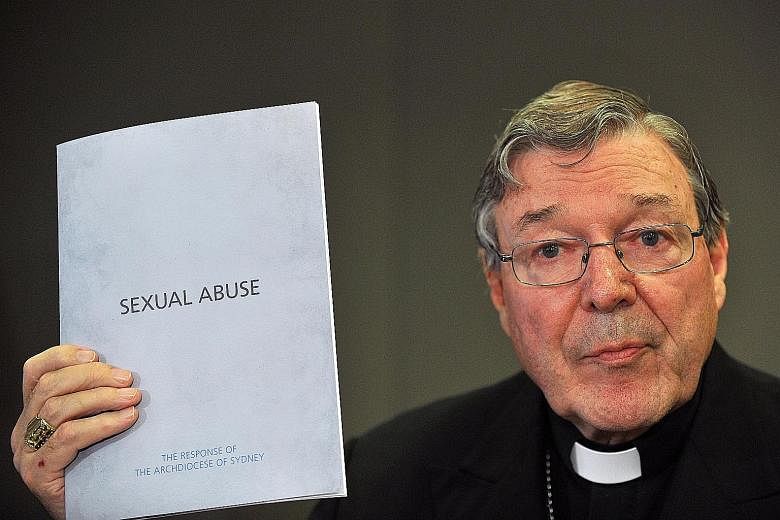 Cardinal George Pell with a folder outlining the Catholic Church's response to Australia's inquiry into sexual abuse in November 2012. Pell now faces multiple charges relating to historical sex offences.