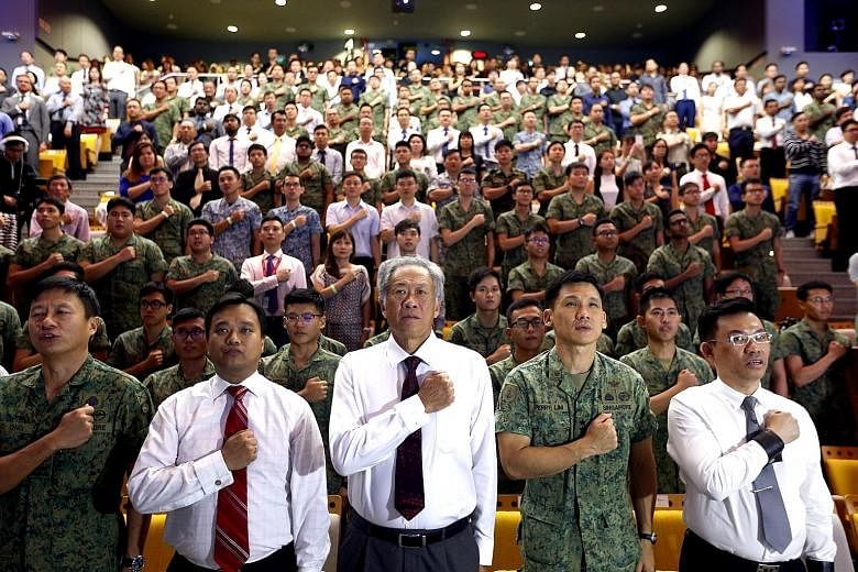 Reciting the SAF pledge at Temasek Polytechnic with NSmen, their employers and civilian colleagues are (from left) Brigadier-General Ong Tze-Ch'in, director of military intelligence; Association of Small and Medium Enterprises (Asme) president Kurt W