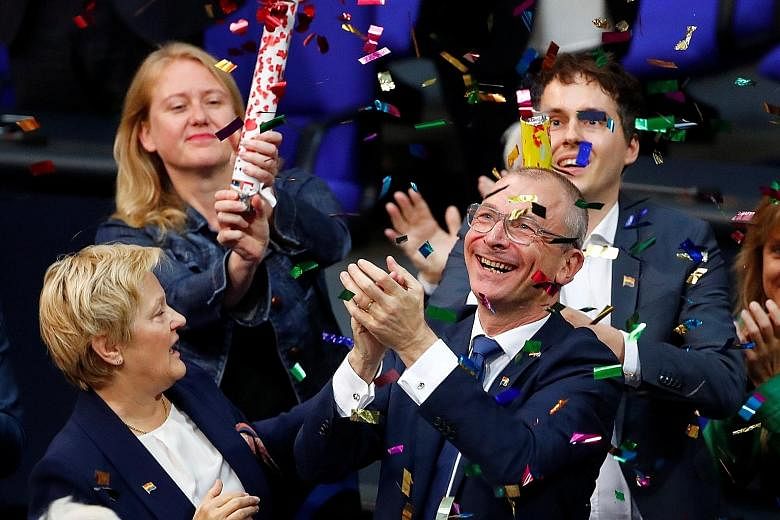 German politician Volker Beck (foreground) celebrating after the gay marriage law was passed in the lower house of Parliament yesterday. The law passed by a margin of 393 to 226, despite the personal objections of Chancellor Angela Merkel.