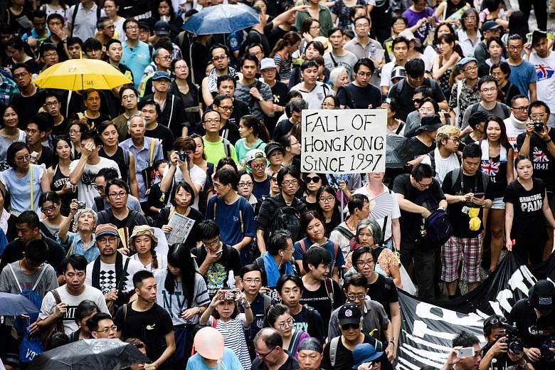 A protest march in Hong Kong yesterday. Thousands of protesters chanting "Reclaim Hong Kong" took to the streets after Mrs Carrie Lam was sworn in as the city's new Chief Executive. More than 20 were arrested.