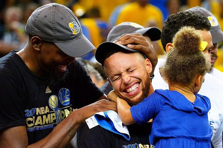 Golden State Warriors guard Stephen Curry (centre) celebrates winning a second NBA championship with his daughter Riley and team-mate Kevin Durant. He is now the highest-paid basketballer in the world.