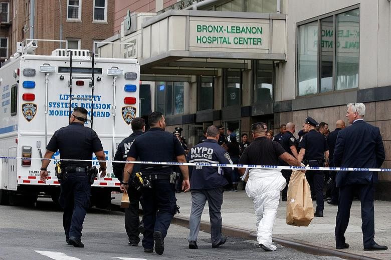 A police detective escorting a patient from the hospital after the rampage. Gunman Henry Bello had set himself on fire and shot himself in the head. The hospital where the shooting took place is one of the Bronx's largest, with 1.1 million patient vi