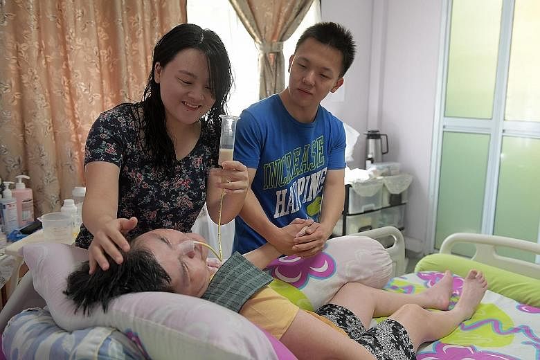 Ms Grace Koh feeding milk to her bedridden mother with the help of her brother Joshua Koh. The siblings, who both have full-time jobs, also look after their father who needs intensive care after a fall left him with a brain injury. "At the end of a l