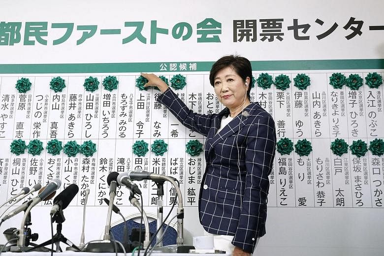 Tokyo Governor Yuriko Koike was kept busy adding paper flowers atop the names of elected members of her Tomin First party as the results came in for the city's metropolitan assembly election yesterday.