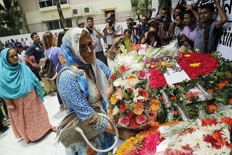 People paying their respects at the new building where the Holey cafe used to be in Dhaka, Bangladesh, on Saturday. Last year's terrorist attack by members of local militant group Jamayetul Mujahideen Bangladesh killed more than 20 people.