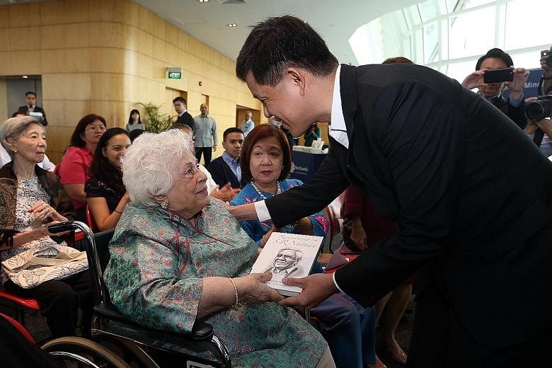 Mr Chan Chun Sing, Minister in the Prime Minister's Office, presenting a copy of Remembering S R Nathan: A Mentor For All Seasons to Mrs Nathan at the launch of the book at the National Library Building yesterday.