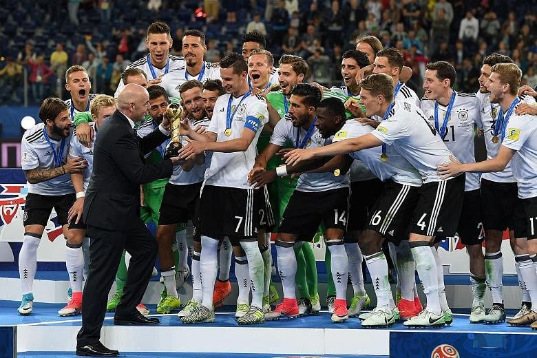 Left: Germany's stand-in captain Julian Draxler receiving the Confederations Cup trophy from Fifa president Gianni InfantinoBelow: Germany forward Lars Stindl slotting home into an empty net for the winner against Chile.Bottom: Forward Timo Werner of