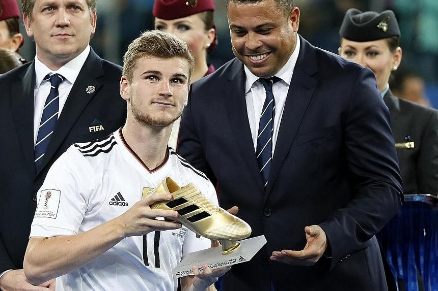Left: Germany's stand-in captain Julian Draxler receiving the Confederations Cup trophy from Fifa president Gianni InfantinoBelow: Germany forward Lars Stindl slotting home into an empty net for the winner against Chile.Bottom: Forward Timo Werner of