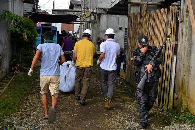 A group of rescue volunteers carrying a body on May 28 that they found at the beginning of the fighting between government troops and militants in Marawi.