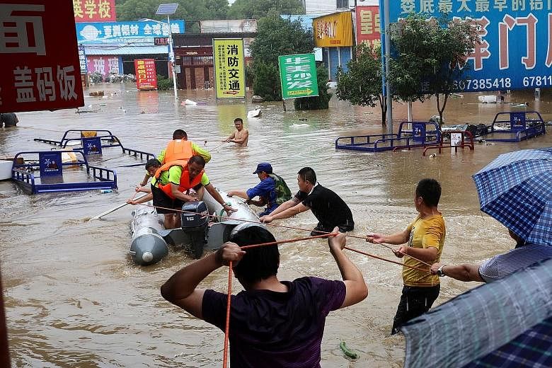 Rescuers evacuating residents from a flooded area in Loudi city, Hunan province, on Saturday. The floods have also delayed grain on barges and damaged farms along the Yangtze River.