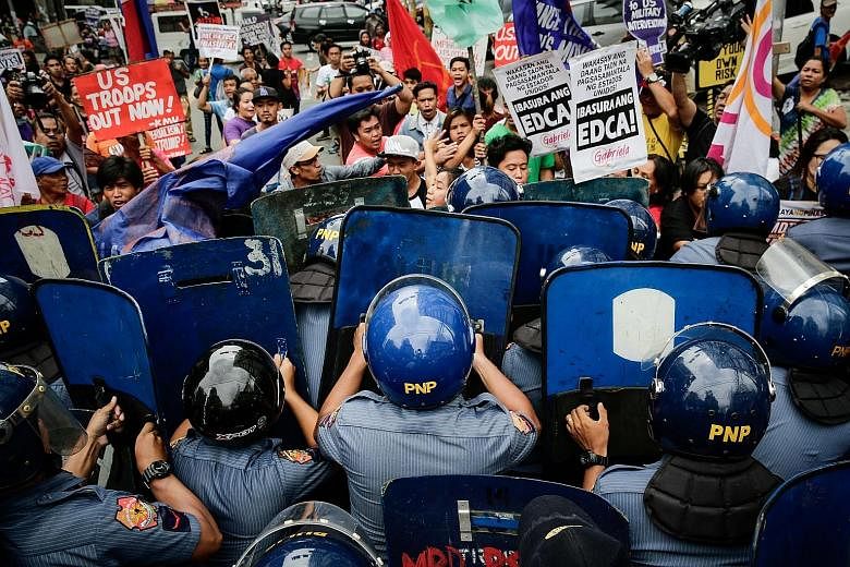 Activists clashing with anti-riot police during a protest near the United States Embassy in Manila yesterday. The activists were calling for an end to US military intervention in Marawi and Mindanao. Philippine President Rodrigo Duterte had declared 