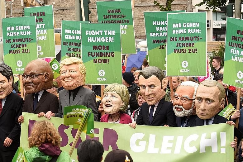Protesters wearing masks of G-20 leaders on Sunday, ahead of tomorrow's G-20 summit in Hamburg, Germany.