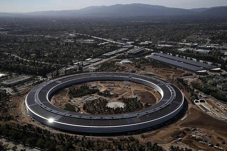 Spanning 2.8 million sq ft, Apple's new home includes a futuristic glass building (left).
