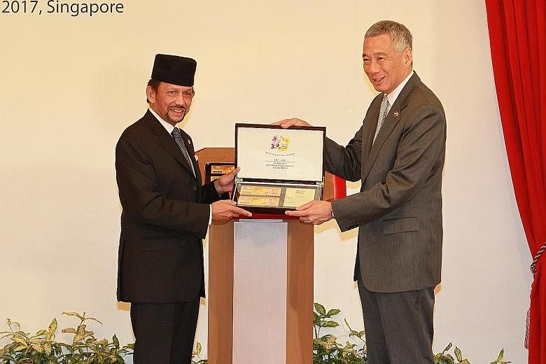 Sultan Hassanal Bolkiah and Prime Minister Lee Hsien Loong at the launch of the special commemorative notes marking the golden jubilee of the Currency Interchangeability Agreement between Brunei and Singapore. Brunei Sultan Hassanal Bolkiah inspectin