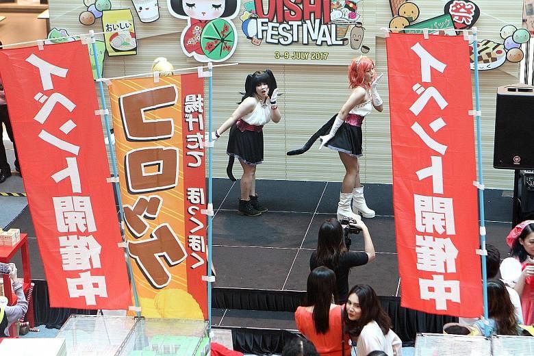 Cosplayers performing at the Cold Storage Oishi Festival Atrium Fair at Plaza Singapura yesterday. Among the food offerings at the fair were crispy croquettes and beef rice bowls, as well as Hokkaido cheesecakes and lavender ice cream. The festival w