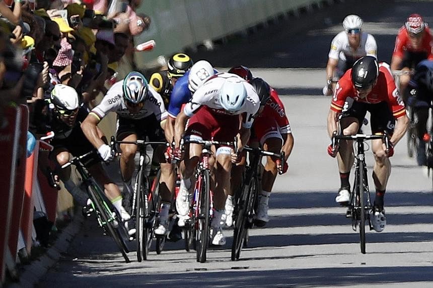 Astana rider Fabio Aru of Italy powering home to win the Tour de France fifth stage. Below: Bora-Hansgrohe cyclist Peter Sagan catching Dimension Data's Mark Cavendish with a stray elbow during the final sprint of the fourth stage. The resultant cras