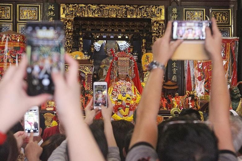 Right: Dancers from Meizhou performing as part of a ceremony in honour of Mazu. Above: Thousands of devotees were at Thian Hock Keng temple yesterday to see the statue.