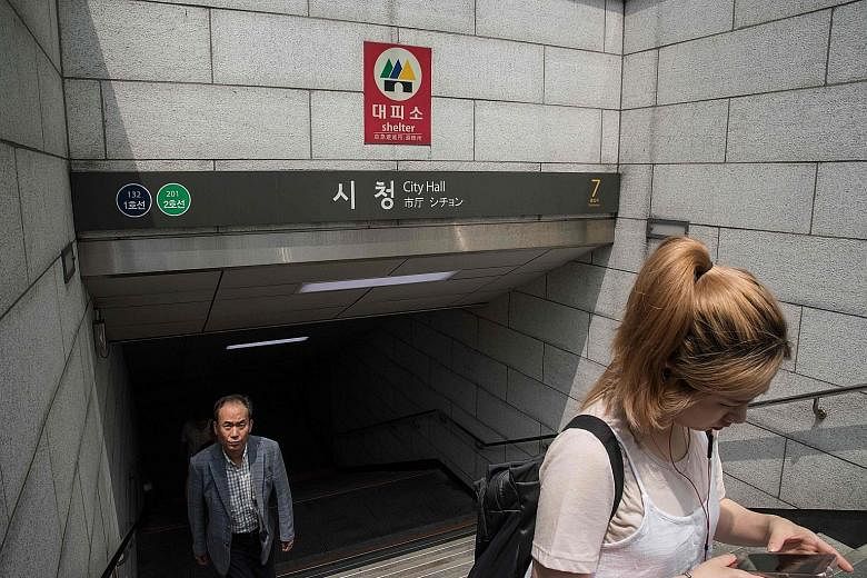 A "shelter" sign is displayed at the entrance to a subway station in Seoul. The subway stations serve a dual purpose with over 3,000 designated as shelters in case of aerial bombardment.