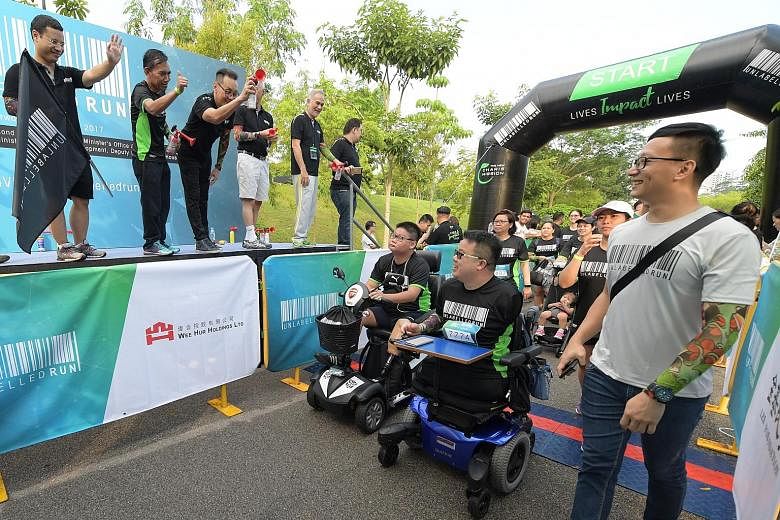 Second Minister for Home Affairs Desmond Lee (left, with a tattoo sleeve) flagging off the run yesterday. With him on stage was Berita Harian Editor Saat Abdul Rahman (second from left) and New Charis Mission executive director Don Wong (third from l